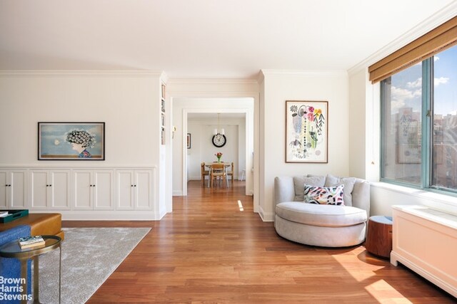 sitting room featuring ornamental molding and light hardwood / wood-style flooring