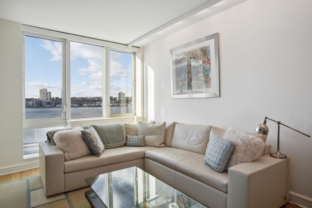 living room featuring a city view, baseboards, and wood finished floors