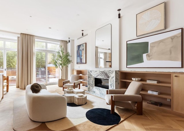 living area featuring a premium fireplace and light parquet flooring