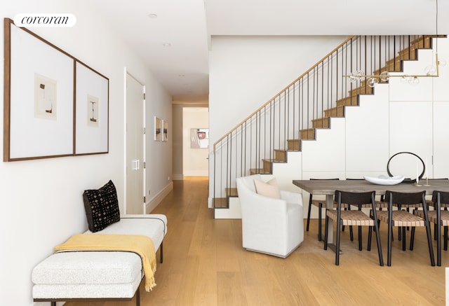 stairs with baseboards, wood finished floors, and visible vents