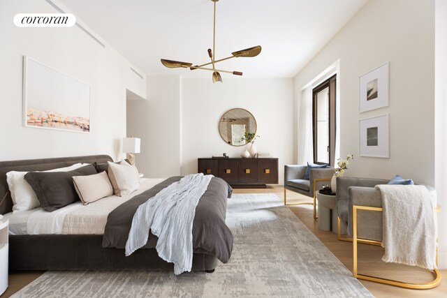bedroom with visible vents, wood finished floors, and a chandelier