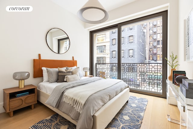 bedroom featuring wood finished floors, visible vents, and access to outside