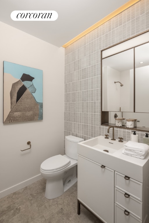 bathroom with vanity, tile walls, and toilet