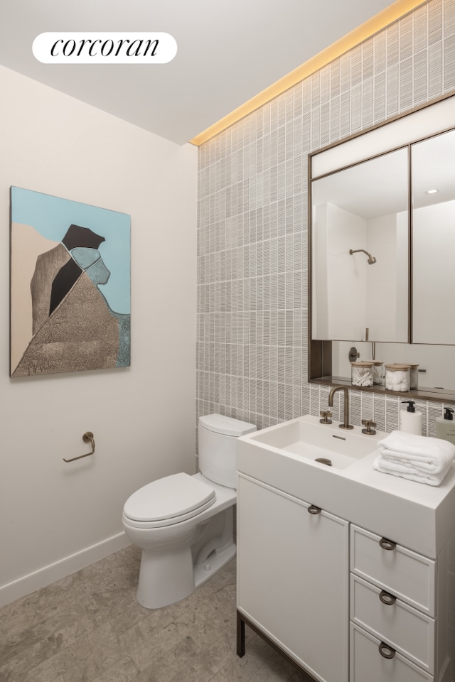 bathroom featuring baseboards, vanity, and toilet