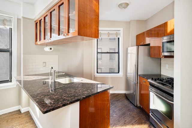 kitchen featuring a sink, stainless steel appliances, dark wood finished floors, and brown cabinetry