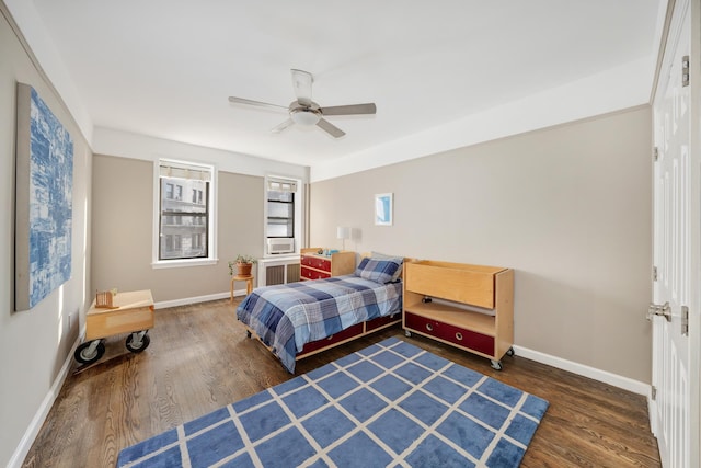 bedroom with radiator, wood finished floors, baseboards, and ceiling fan