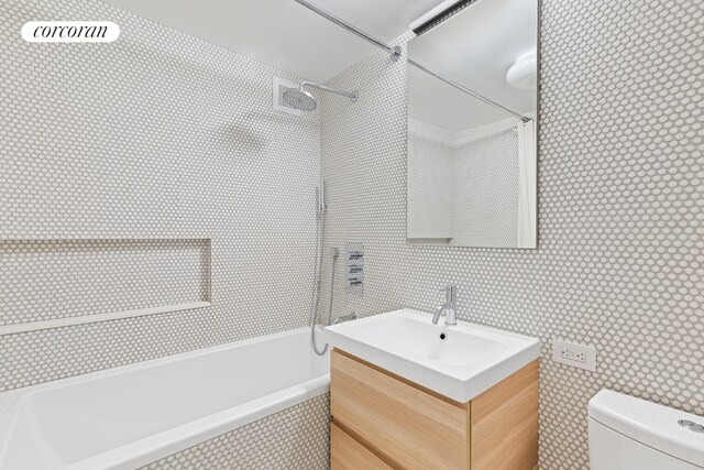 full bathroom with vanity, tiled shower / bath, and toilet