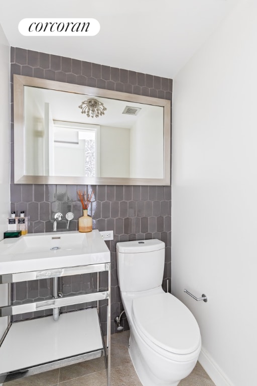 bathroom featuring tile walls, vanity, tasteful backsplash, and toilet