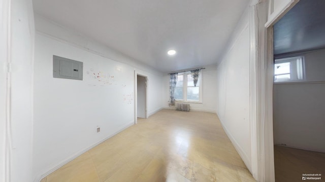 unfurnished room featuring electric panel, baseboards, and radiator