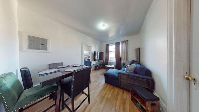 dining area with electric panel and light wood-style floors