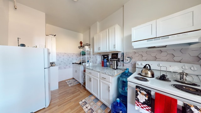 kitchen with white appliances, white cabinets, light wood-style floors, and under cabinet range hood