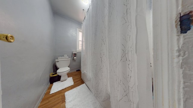 bathroom with toilet and wood finished floors