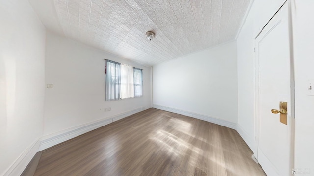 empty room with baseboards and wood finished floors