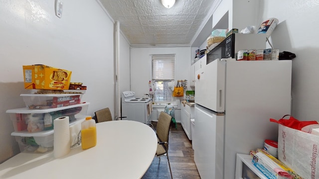 kitchen with an ornate ceiling, washer / clothes dryer, wood finished floors, and freestanding refrigerator