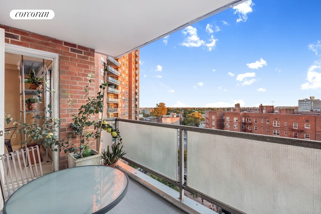 balcony with outdoor dining area, visible vents, and a city view