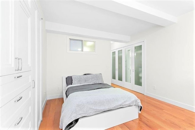 bedroom featuring light wood finished floors and baseboards