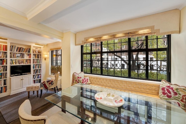 living area with beam ceiling and crown molding