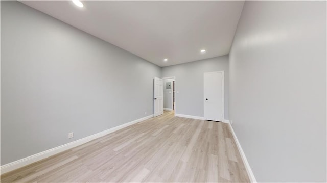 unfurnished room featuring recessed lighting, light wood-type flooring, and baseboards