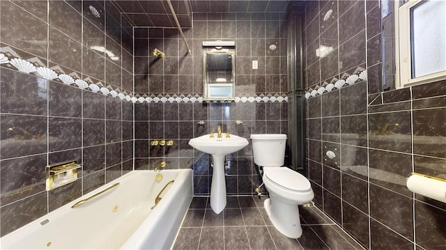 bathroom featuring tile patterned floors, toilet, a washtub, and tile walls