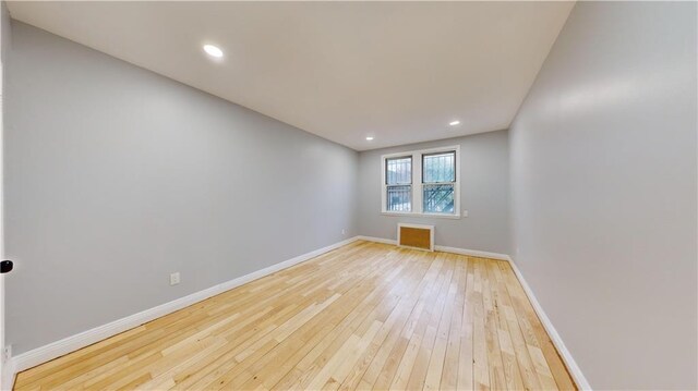 empty room with recessed lighting, baseboards, and wood-type flooring