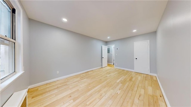 spare room featuring recessed lighting, baseboards, and hardwood / wood-style floors