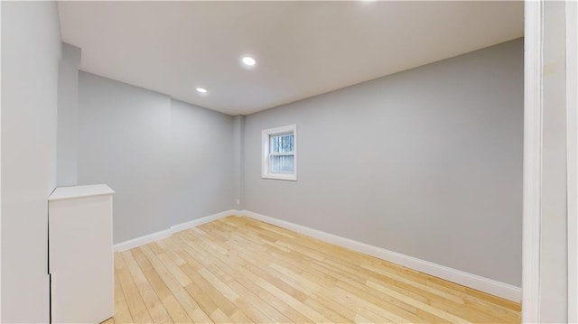 empty room featuring recessed lighting, baseboards, and light wood-type flooring