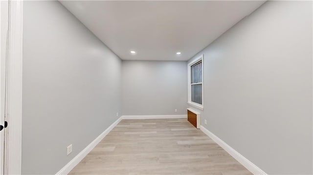 unfurnished room featuring recessed lighting, light wood-type flooring, and baseboards