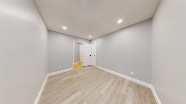 unfurnished room with recessed lighting, light wood-type flooring, and baseboards