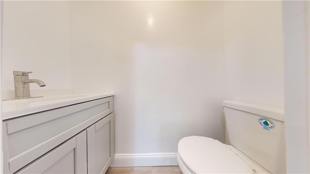 bathroom featuring vanity, toilet, and baseboards