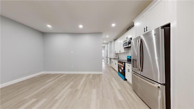 kitchen featuring baseboards, white cabinets, light wood-style floors, appliances with stainless steel finishes, and tasteful backsplash