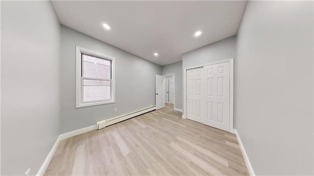 unfurnished bedroom featuring recessed lighting, baseboards, light wood finished floors, and a baseboard radiator