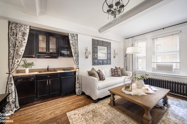 living room featuring radiator heating unit, beamed ceiling, wood-type flooring, sink, and cooling unit