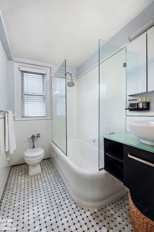 full bathroom with vanity, tub / shower combination, tile walls, and toilet