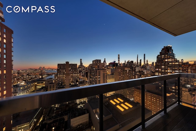 balcony at dusk featuring a city view