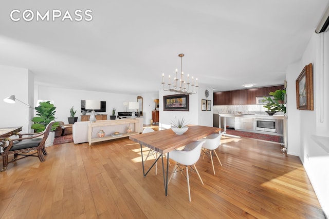 dining area featuring light wood-style floors and an inviting chandelier