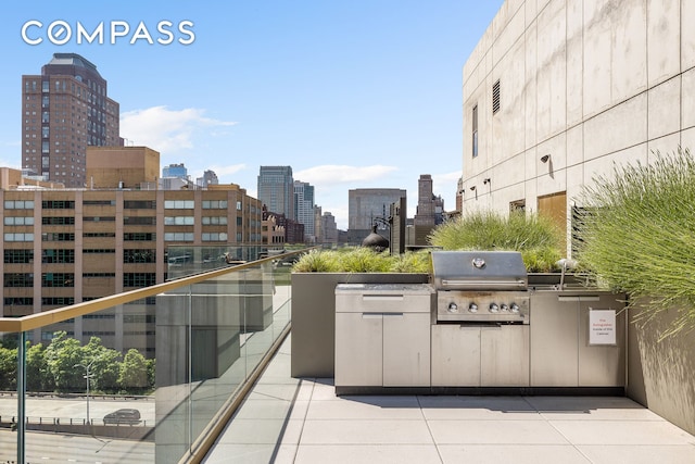 view of patio / terrace with area for grilling, a city view, and an outdoor kitchen