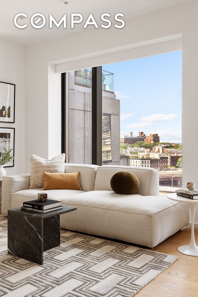 living area with a view of city and wood finished floors