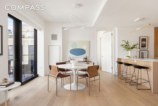 dining room with visible vents and light wood-type flooring