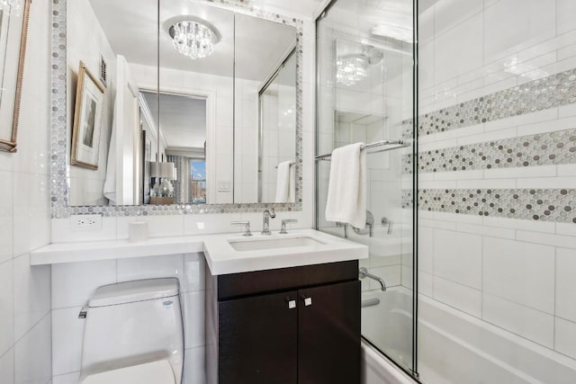 full bathroom featuring enclosed tub / shower combo, vanity, decorative backsplash, and tile walls