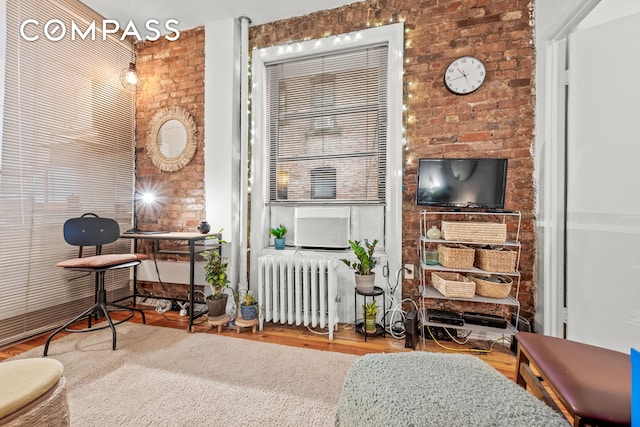 sitting room featuring radiator and wood finished floors