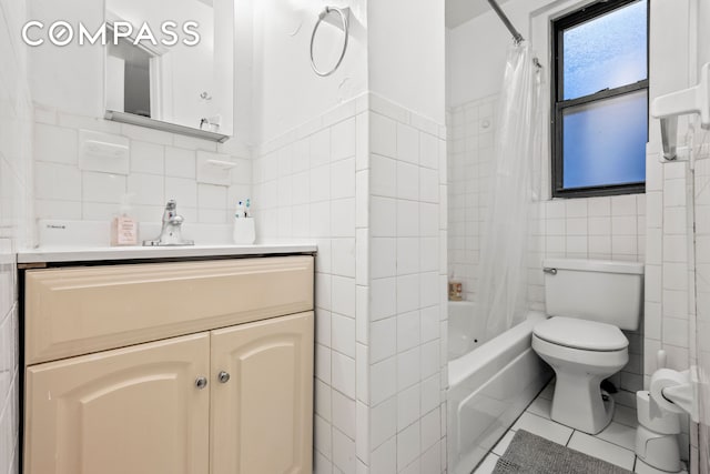 full bathroom with toilet, vanity, shower / bath combo, tile patterned floors, and tile walls