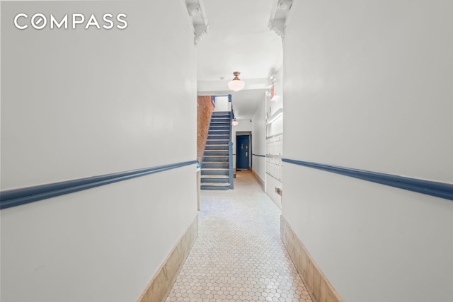 hall featuring stairs and light tile patterned floors