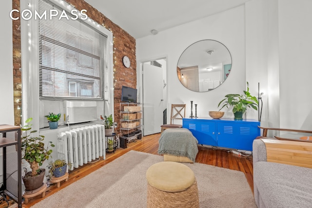 living area featuring wood finished floors and radiator heating unit