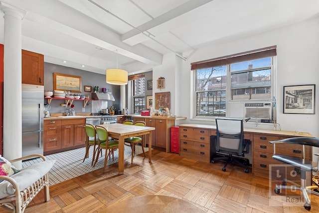 interior space featuring light countertops, hanging light fixtures, brown cabinetry, and appliances with stainless steel finishes