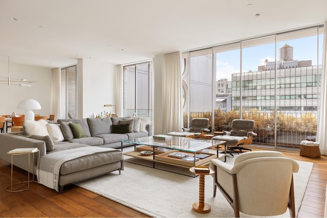 living area featuring hardwood / wood-style floors, plenty of natural light, expansive windows, and a city view
