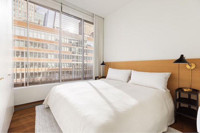 bedroom featuring floor to ceiling windows and wood finished floors