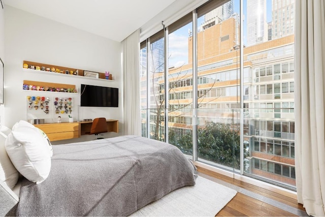 bedroom featuring access to exterior, built in desk, and wood-type flooring