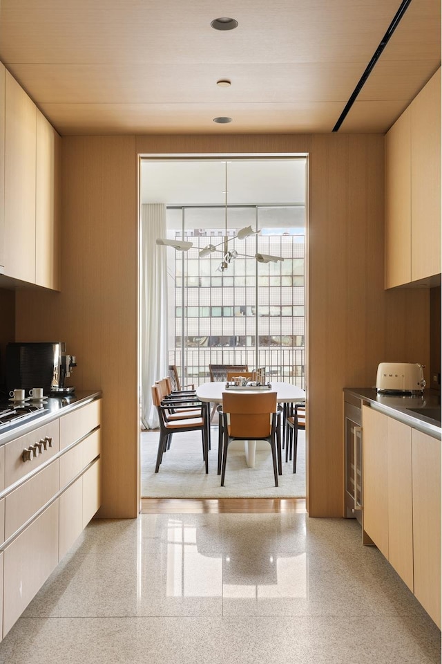 kitchen with wood walls, modern cabinets, and a notable chandelier