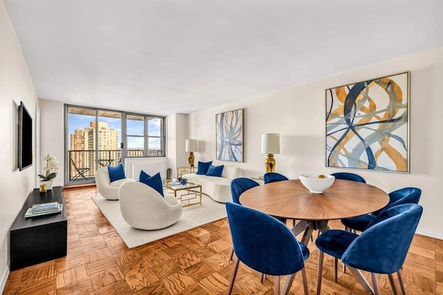 dining space featuring floor to ceiling windows and parquet flooring