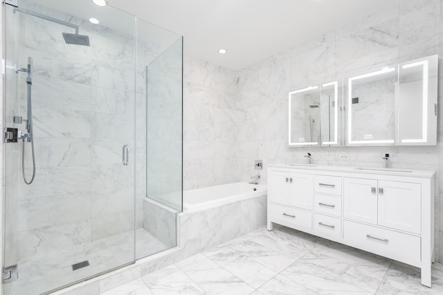 bathroom featuring a marble finish shower, a bath, marble finish floors, double vanity, and recessed lighting
